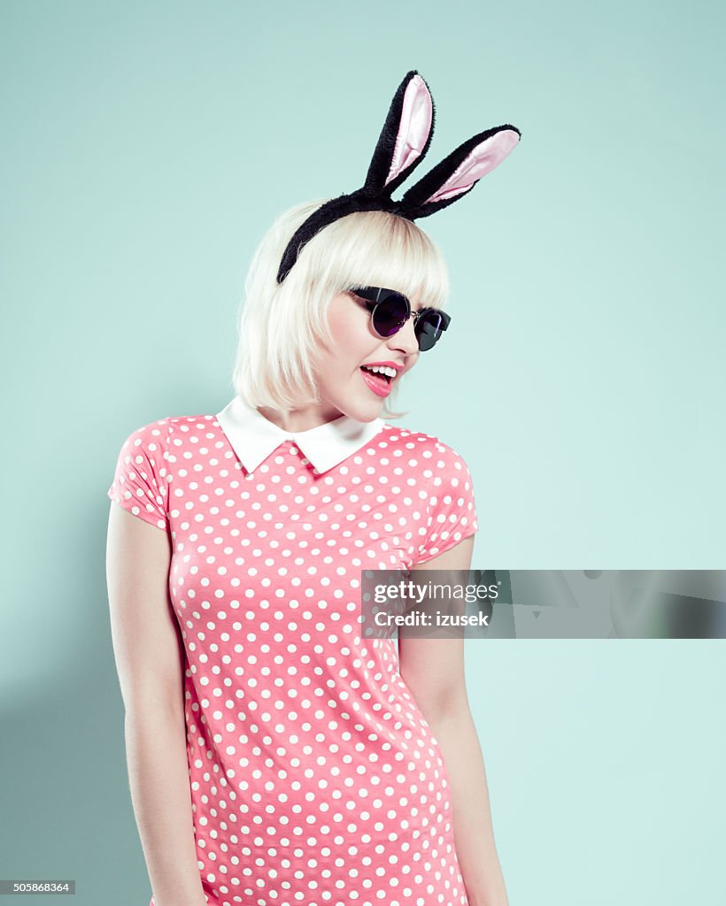 Chick blonde young woman wearing rabbit ears headband and sunglasses