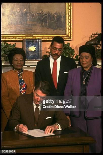 President Ronald Reagan signing Martin Luther King Jr. Day holiday proclamation with his Dr. King's widow Coretta Scott King, son Dexter & sister...