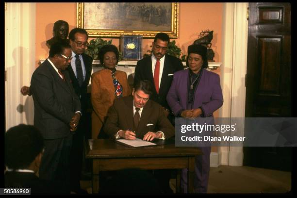 President Reagan signs Martin Luther King Jr. Day holiday proclamation, with Coretta Scott King, son Dexter, sister-in-law Christine Farris, Pierce &...