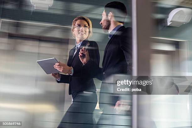 deux collègues d'affaires marchant le long de la passerelle - motion photos et images de collection