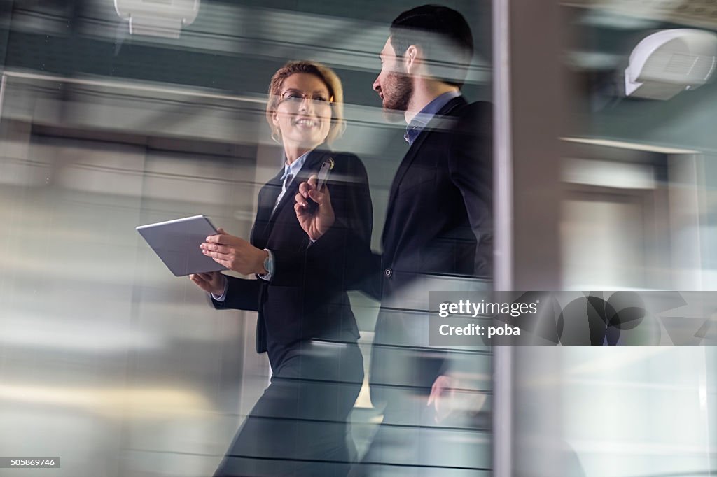 Two Business coworkers walking along elevated walkway