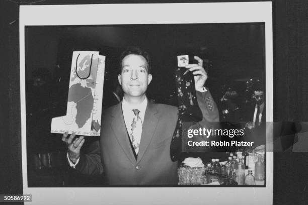 Rock musician Fred Schneider holding up a pair of E. G. Smith socks & bag they came in, at 7th Ave on Sale AIDS benefit.