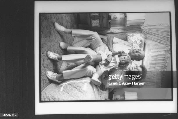 Fred & Mildred Kassab, parents of murder victim Colette MacDonald, sit on bed holding one of her blonde girl baby dolls as they mourn her death at...