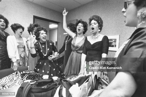 Eight of the ten member Ethel Merman Memorial Choir, wearing wigs & dresses as they imitate their idol by belting rendition of one of the songs she...