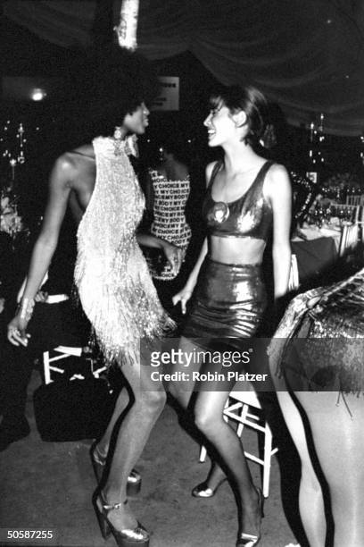Models Christy Turlington & bewigged Naomi Campbell , dancing the glitter bug, in skimpy outfits at 7th Ave on Sale AIDS benefit.