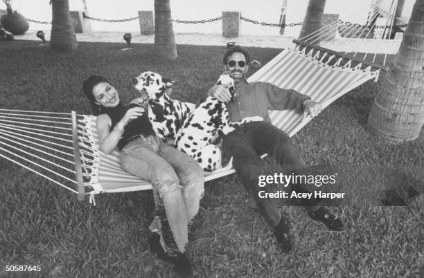 Gloria Estefan resting in hammock w. 2 dalmatians & husband Emilio after she recovered from accident which broke a vertebra in her spine, making a...