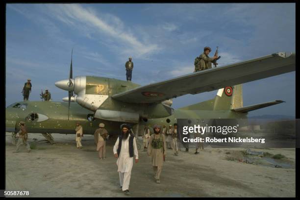 Mujahedeen w. Antonov-32 Soviet-made cargo plane at mil. Airport in garrison city rebels seized fr. Kabul troops in 16-day battle.