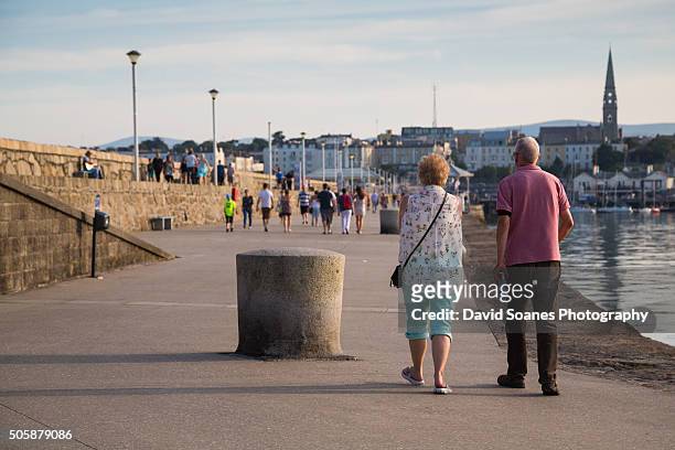 people walking along dun laoghaire pier in dublin, ireland - dun laoghaire stock-fotos und bilder