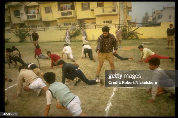 Youths during calisthenics exercises, in early AM physical training shaka of RSS, Rashtriya Swayamsevak Sangh, Hindu cultural org.