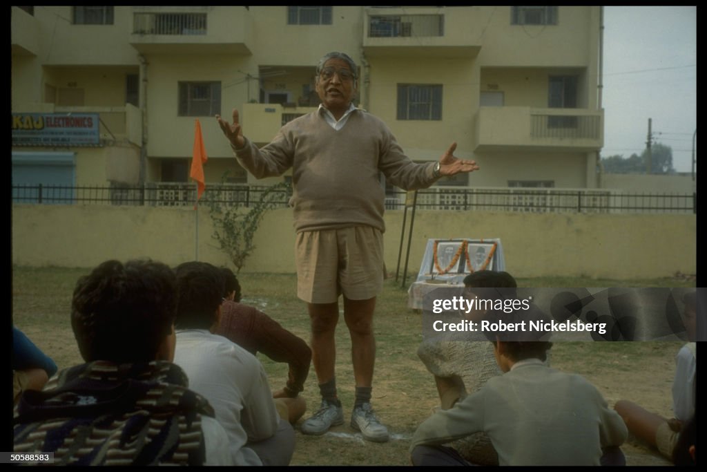 Youths being lectured, sitting outside,