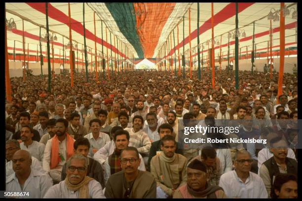 Huge crowd of Hindu nationalist Bharatiya Janata supporters attending BJP convention, sitting in party colors-roofed tent.