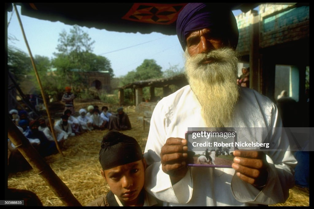 Elderly Sikh w. pic of his dead militant