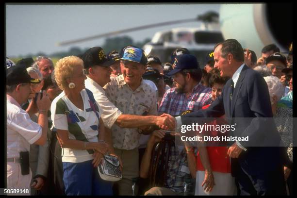 Pres. Bush shaking hands w. Some of 500 WWII vets & family fr. His USS San Jacinto VT 51 Squadron, at Andrews AFB.