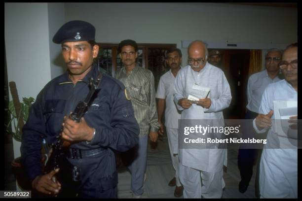 Hindu nationalist BJP ldr. L.K. Advani , Bharatiya Janata Party parliamentary cand., w. Others in tow & rifle-toting mil-type guard in fore.