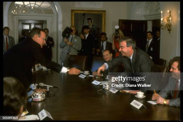 Pres. Bush reaching over table to shake hands w. Soviet Mideast envoy Yevgeny Primakov, mtg. In WH Cabinet Rm.