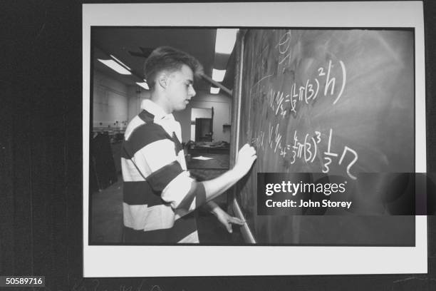 Yale Univ. Student Matt Keary writing physics equation on blackboard in physics lab after receiving The Carol Dimaiti Stuart Foundation scholarship...