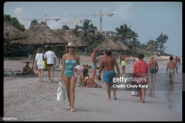 Tourists sunning & strolling on beach in fast-developing Varadero Beach resort area.