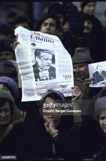 Supporters of Boris Yeltsin rallying for reform-minded, opposition maverick, waving newspapers bearing his image, at Luzhniki stadium election event.