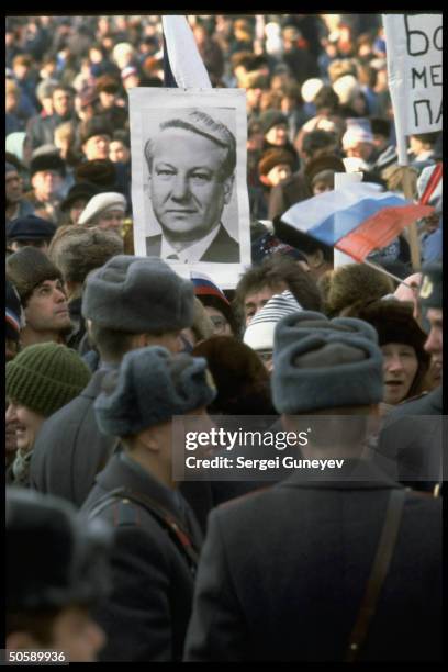 Supporters of populist Russian ldr. Yeltsin w. His portrait, amid sea of pro-democracy protestors ringed by Interior Ministry police.