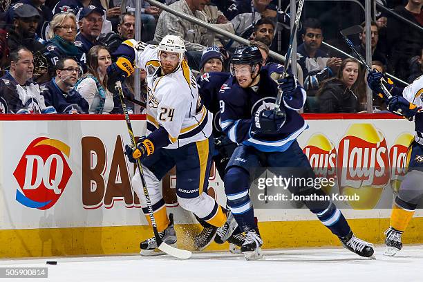 Eric Nystrom of the Nashville Predators and Andrew Copp of the Winnipeg Jets chase the loose puck up the ice during second period action at the MTS...