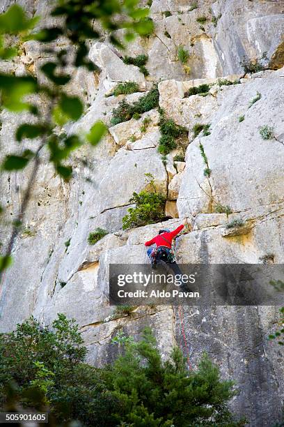 climbing a rocky peak, baunei,  cala goloritzé - cala goloritze stock-fotos und bilder