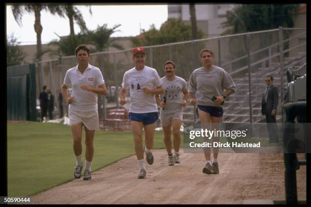 Pres. Bush out on (his read my hips jog, running w. His son Jeb & secret servicemen, at St. Petersburg Stadium.