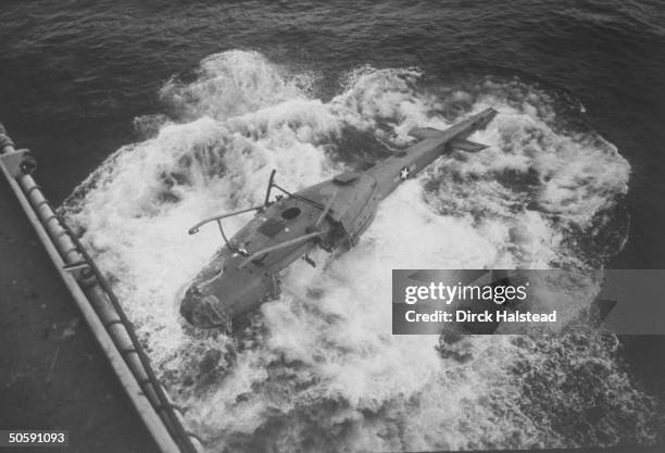 Upside-down US military helicopter being ditched in the S. China Sea from the USS Blue Ridge after final evacuation from Vietnam.