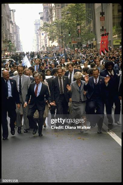 Gov. Cuomo, VP cand. Gerry Ferraro, Pres. Cand. Mondale & Mayor Ed Koch marching in Columbus Day Parade, framed by crowd.