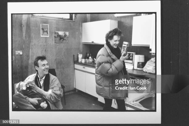 Actor Anthony Head bottle-feeding baby daughter Daisy as live-in lover Sarah Fisher, in down jacket, holds up a jar of Gold Blend coffee, the English...