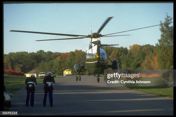 Pair of Marine guards bowing, prob. Recoiling fr. Gust-creating Marine One copter, during Pres. Bush's arrival/departure for spot of golfing.