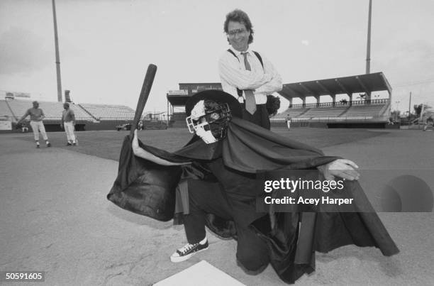 Mike Veeck, pres. Of Miracle, a minor league baseball team, posing behind the Phantom of the Ball Yard, a man in cloak and black-and-white catcher's...