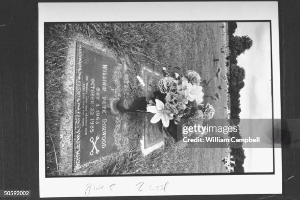 Closeup of bouquet of flowers in cemetery on the gravestone of William Pete Norwood who was killed during a robbery at the gas station where he...