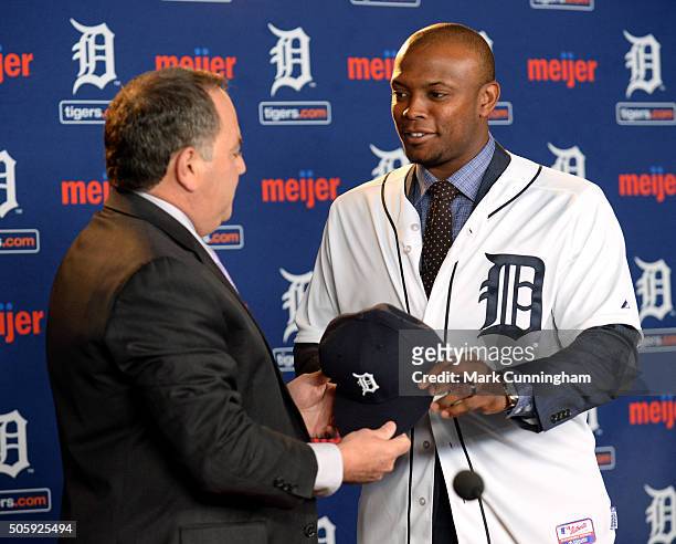 Detroit Tigers Executive Vice President of Baseball Operations and General Manager Al Avila hands a baseball hat to newest Tiger Justin Upton during...