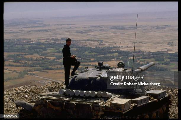 Govt. Soldier w. Soviet tank at mil. Outpost, calm re non aggression protocol between bribed Mujahedeen & army, at Wajjan Gorge overlooking Logar,...