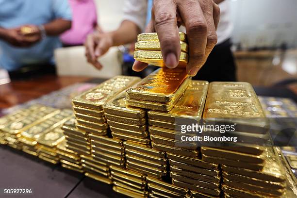 An employee arranges one kilogram gold bars for a photograph at the YLG Bullion International Co. Headquarters in Bangkok, Thailand, on Wednesday,...