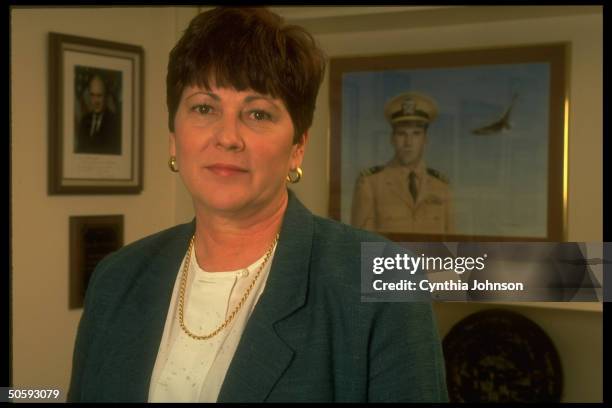 Ann Mills Griffiths, Dir. Of Natl. League of Families , in her office, framed by portrait of her Vietnam war MIA brother.