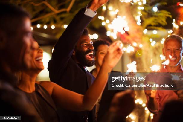 Friends playing with sparklers at party