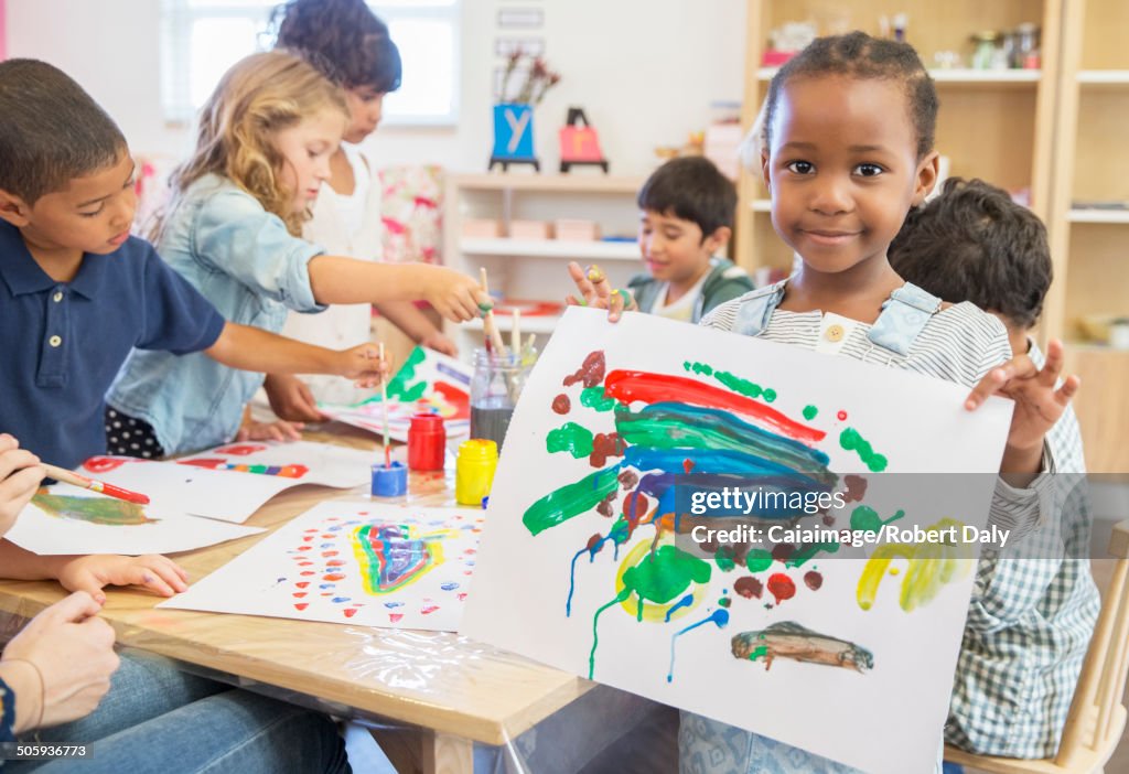 Schüler zeigt Fingermalerei im Klassenzimmer
