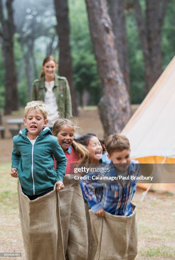 Children having sack race at campsite