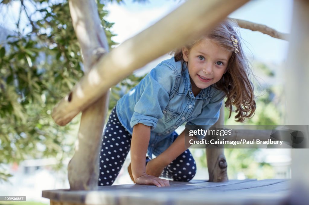 Girl climbing in treehouse outdoors