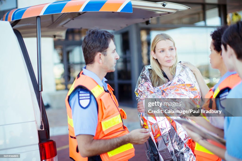 Paramedics talking to patient in hospital parking lot