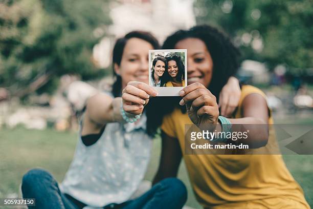 freunde auf einer polaroid-foto - girls photos stock-fotos und bilder