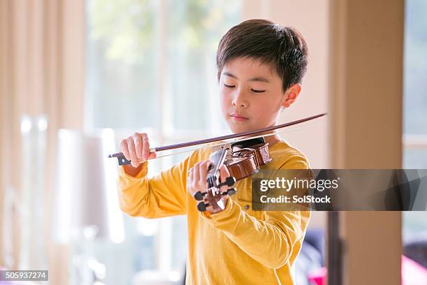 young boy playing violin - boy violin stockfoto's en -beelden