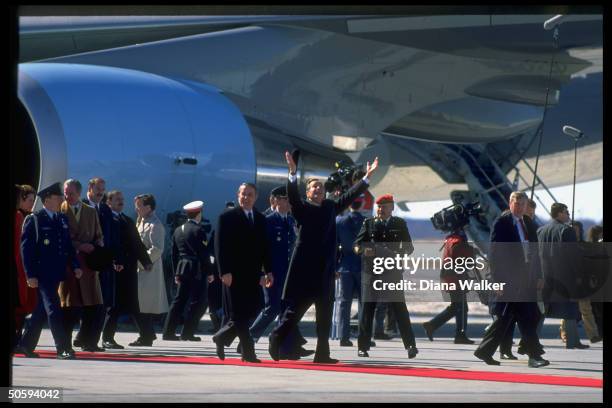 Pres. Mulroney & Pres. Bush treading red carpet, w. Civilian & mil. Entourage in tow, dwarfed by US pres. Plane, at airport arrival fete.