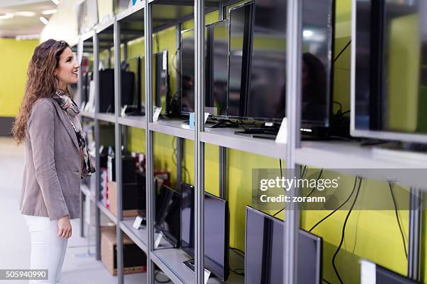 woman choosing new tv - elektromarkt stockfoto's en -beelden