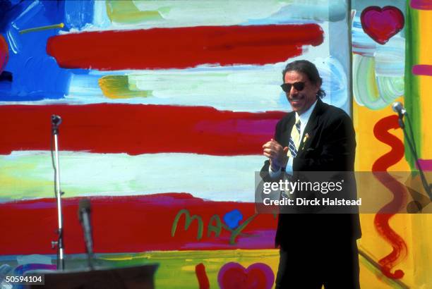 Artist Peter Max framed by his signed flag ptg., during Bush WH Points of Light celebration.