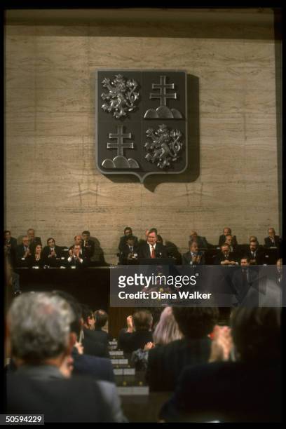 Pres. Bush addressing Federal Assembly, facing & framed by applauding legislators, w. Pres. Havel .