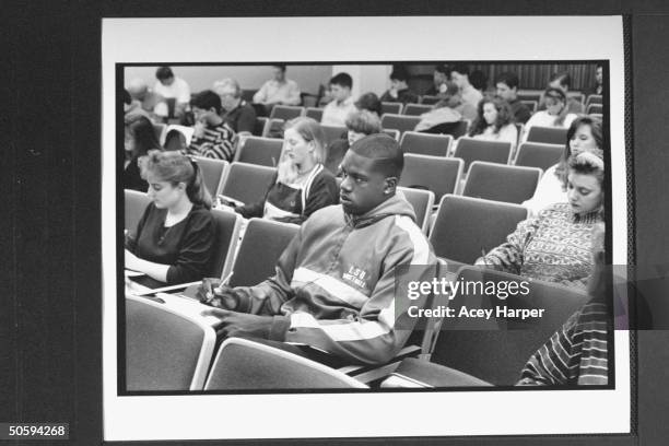 St. Univ. Basketball star Shaquille O'Neal taking notes at lecture.