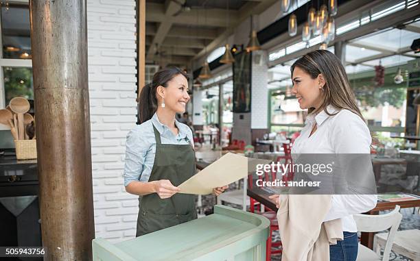 friendly hostess working at a restaurant - hostesses stockfoto's en -beelden