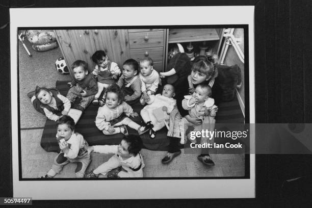 Group of eleven Bosnian war orphans sitting on mattress on floor in group home; the orphans were part of the 44 children who were driven through...